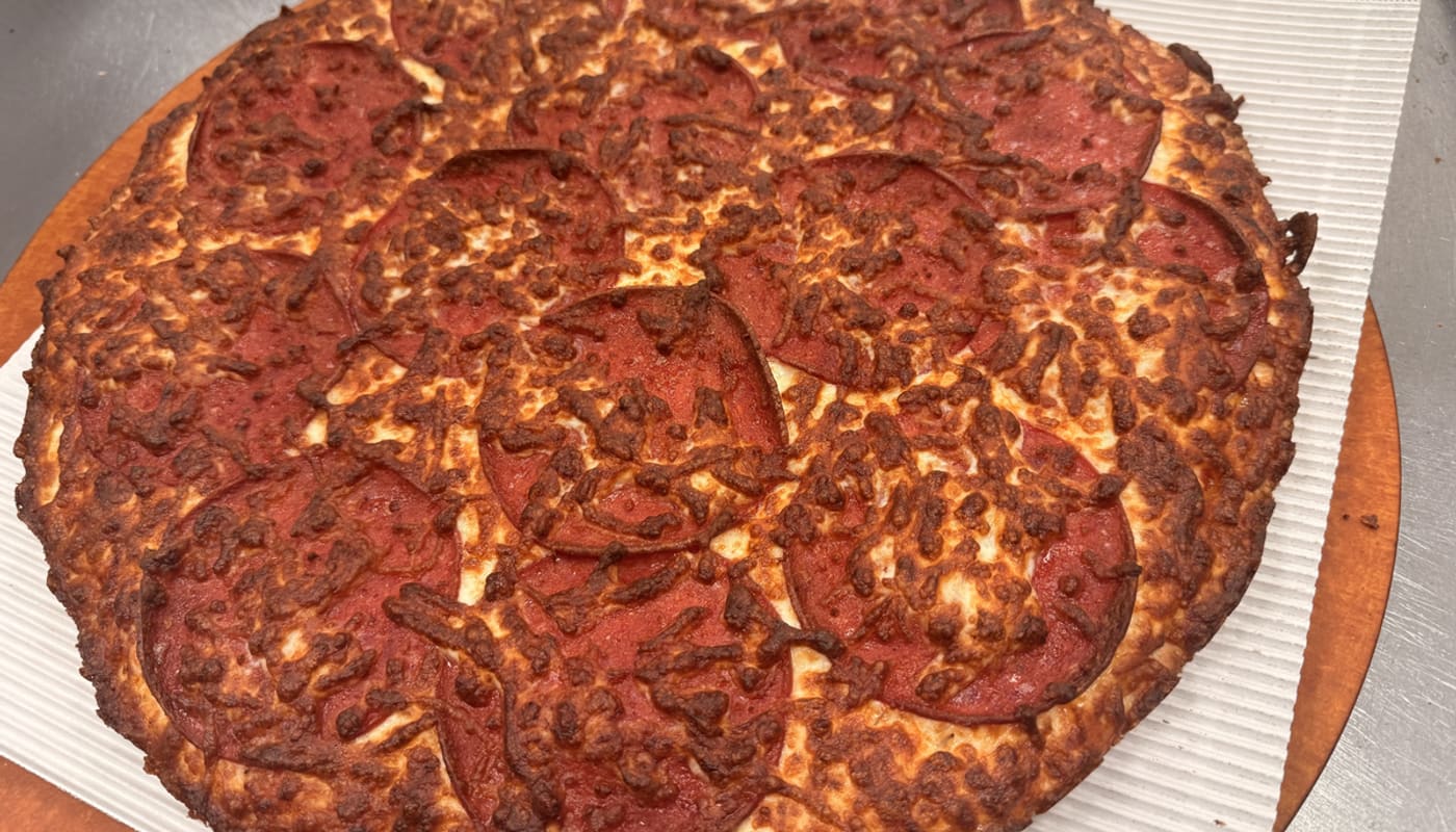 A fresh pepperoni pizza on the board at Captain Pizza Fox Creek