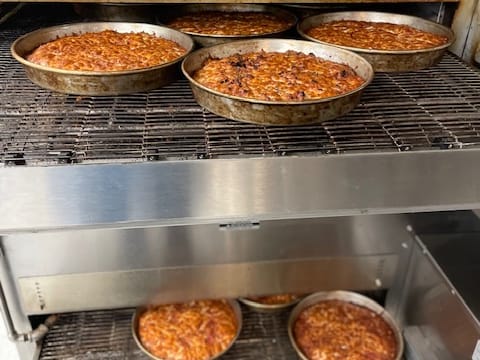 Pizzas coming through the conveyor oven
